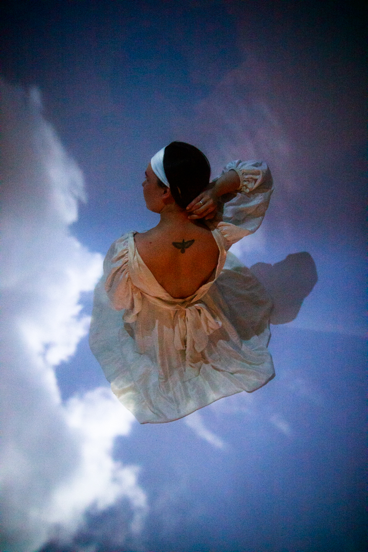 A women sitting in the sky showing her backless dress.